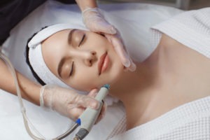 woman receives hydrafacial therapy on jawline