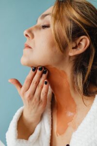 Portrait of Woman Applying Thick Layer of Foundation to Neck